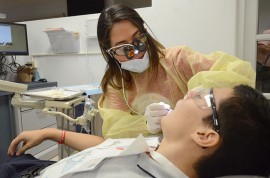 Arriba, una estudiante de Medicina Dental ofrece servicios gratuitamente a un niño, como parte de las actividades celebradas en el Recinto de Ciencias Médicas. (Foto Ricardo Alcaraz-Diálogo)