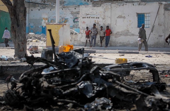 En grupo de somalíes miran un auto destruido por una bomba luego de un ataque suicida del grupo extremista al-Shabab en el 2013, quienes se autoproclamaron autores de la masacre en el Colegio Universitario de Garissa en Kenia. (Stuart Price / Flickr Commons)