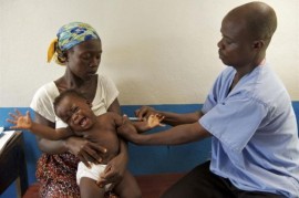 Un bebé recibe la vacuna contra el sarampión de manos del vacunador Joseph Kamara, en la clínica comunitaria de Tagweh, Liberia. Crédito: Unicef