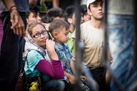 Inmigrantes esperan ser registrados en la isla de Kos, a pocos kilómetros de la costa turca. Ahora, desde que se instaló un centro de registro en un barco atracado en la isla, el proceso es más fácil para los sirios. Para otros, como esta mujer y su hijo, la espera continúa. Más de 160.000 inmigrantes llegaron a Grecia en lo que va de 2015, casi cuatro veces más que en 2014. Crédito: Foto: Stephen Ryan / FICR