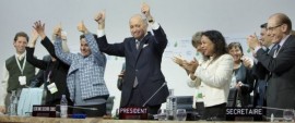 El presidente de la COP21, Laurent Fabius, en el centro, y otros líderes de la cumbre de París aplauden y hacen señales de victoria al lograrse el histórico acuerdo universal y vinculante para afrontar el cambio climático. Crédito: CMNUCC