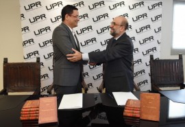Walker Ramos y Rey Hernández celebran la firma del convenio colaborativo por cinco años entre la UPR y la Fundación Puertorriqueña de las Humanidades. (Suministrada / Ingrid Torres)