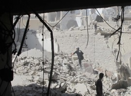 Un miembro del equipo de defensa civil de Alepo busca sobrevivientes tras el ataque aéreo con una bomba de barril en la ciudad siria en agosto de 2014. Crédito: Shelly Kittleson/IPS.