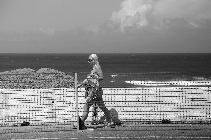Bañista camina por la zona de Puerta de Tierra donde se construye el Paseo Lineal. (Doel Vázquez)