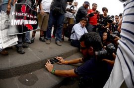 El fotógrafo mexicano Rubén Espinosa coloca una placa en honor de Regina Martínez, el 28 de abril de 2015, en la plaza central de Xalapa, la capital del sureño estado de Veracruz, para conmemorar los tres años del asesinato de la periodista. En julio de ese año, Espinosa fue asesinado también. Crédito: Roger López/IPS
