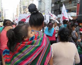 Una migrante de un país andino, con su hija cargada a sus espaldas, reivindica sus derechos con otras mujeres de igual condición, dentro de una manifestación en Buenos Aires, el 24 de marzo, por la verdad y la memoria, en conmemoración del golpe militar en Argentina, en 1976, que impuso hasta 1983 una cruenta dictadura. Crédito: Fabiana Frayssinet/IPS